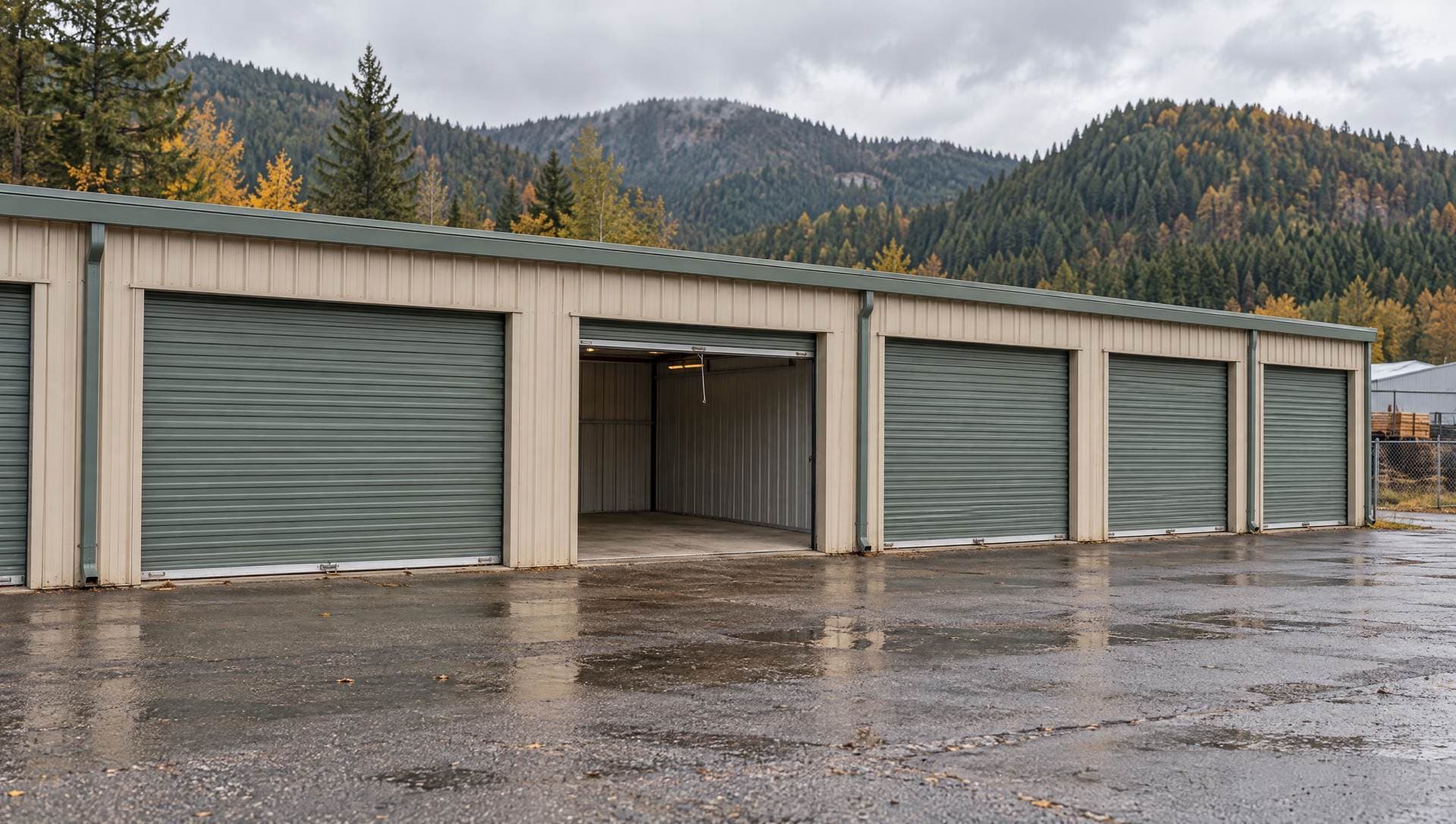 A row of rented storage units with roll-up doors, one open onto an empty unit